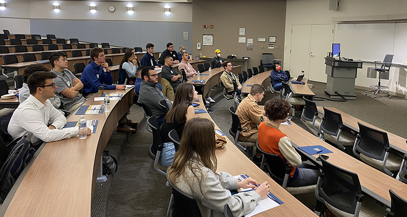 Students in a classroom looking at a screen