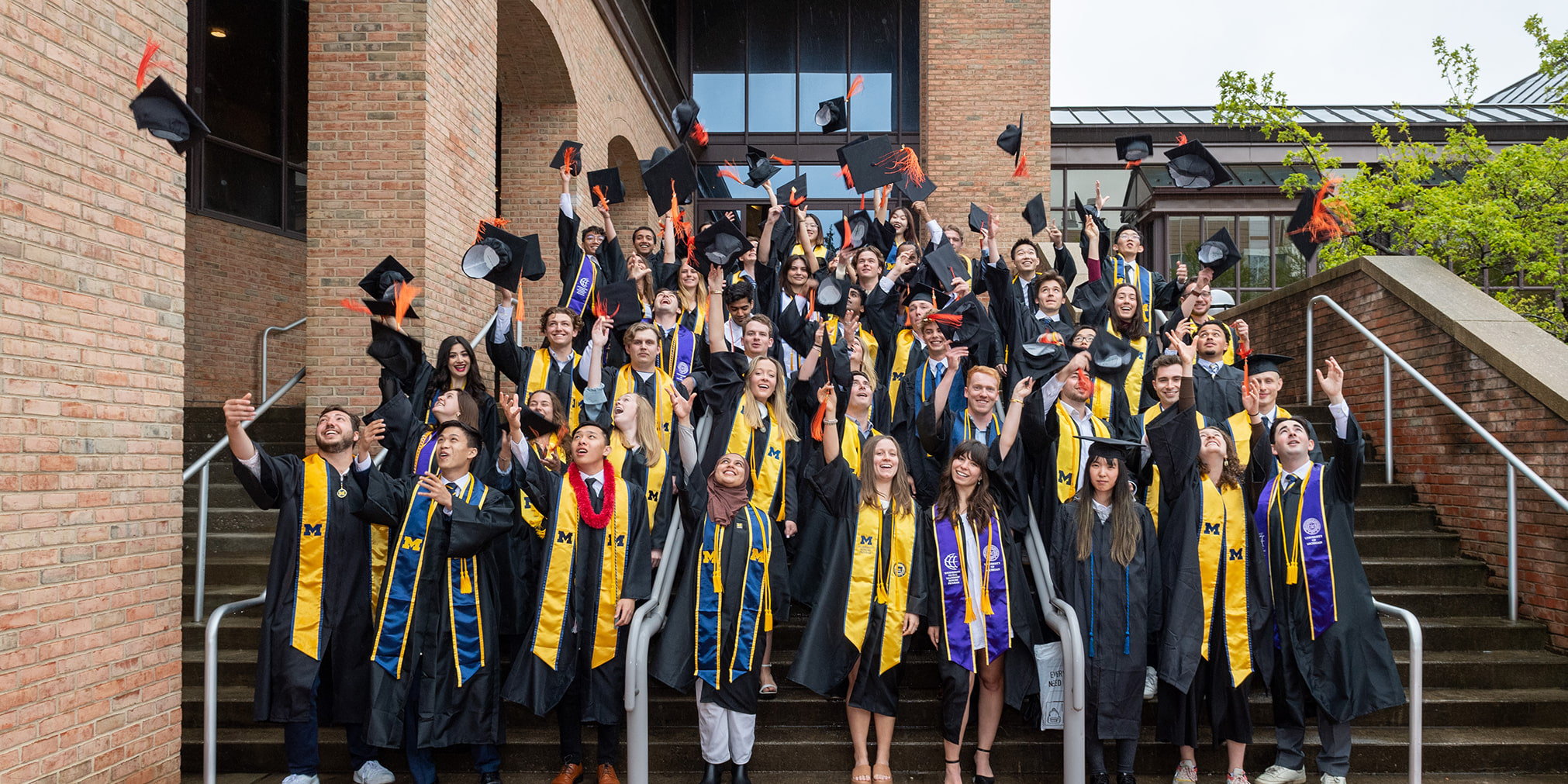 Students throw graduation caps into the air